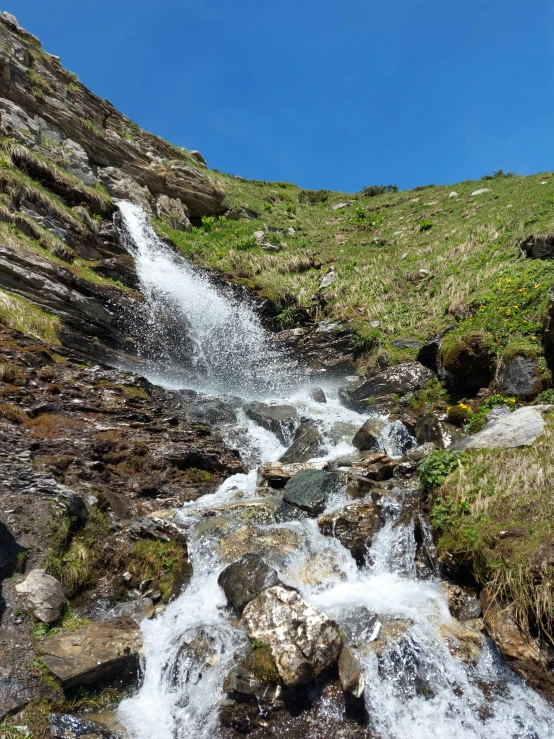 a small waterfall flowing down a hill side
