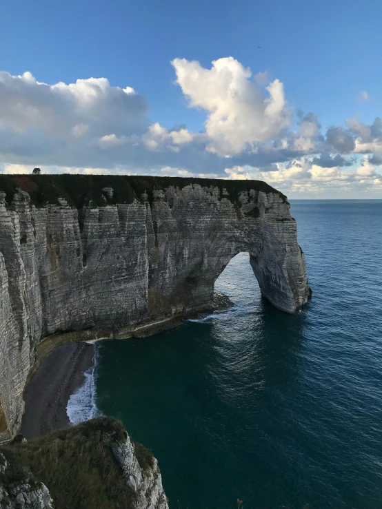 the ocean has green and blue water and cliffs