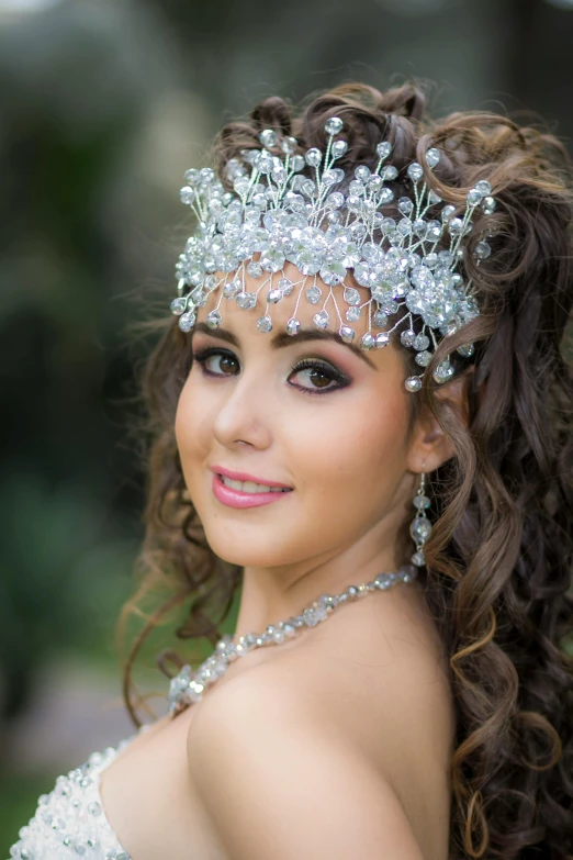 a pretty young lady wearing a head piece with pearls