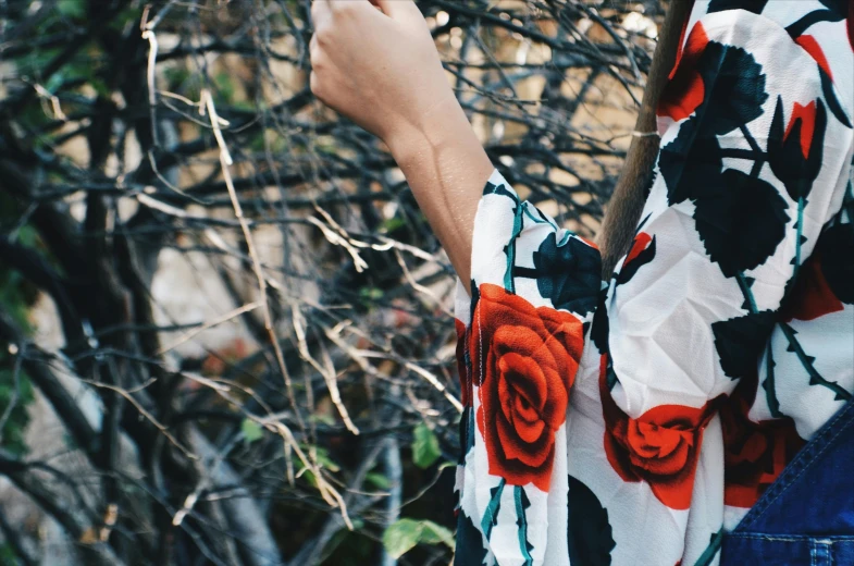 a woman holding an orange flower and pointing to it