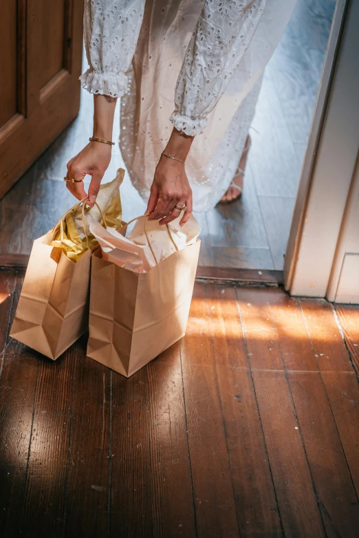 the woman in the dress is putting soing in a brown bag