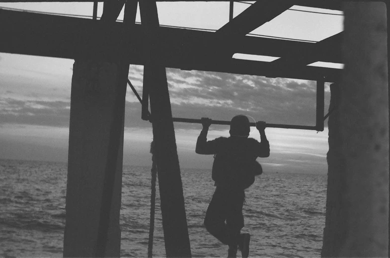 a man standing on the dock holding up a surf board