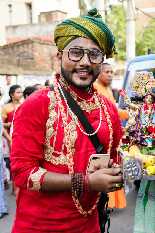 a man dressed in a red turban is smiling