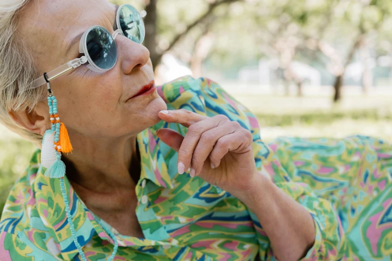 an older woman wearing colorful shirt and sunglasses