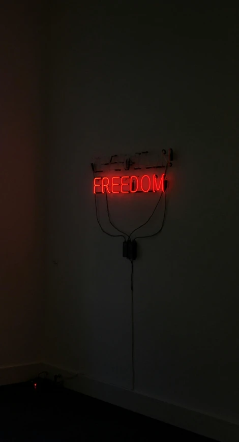 an empty room with neon sign, red light and black background