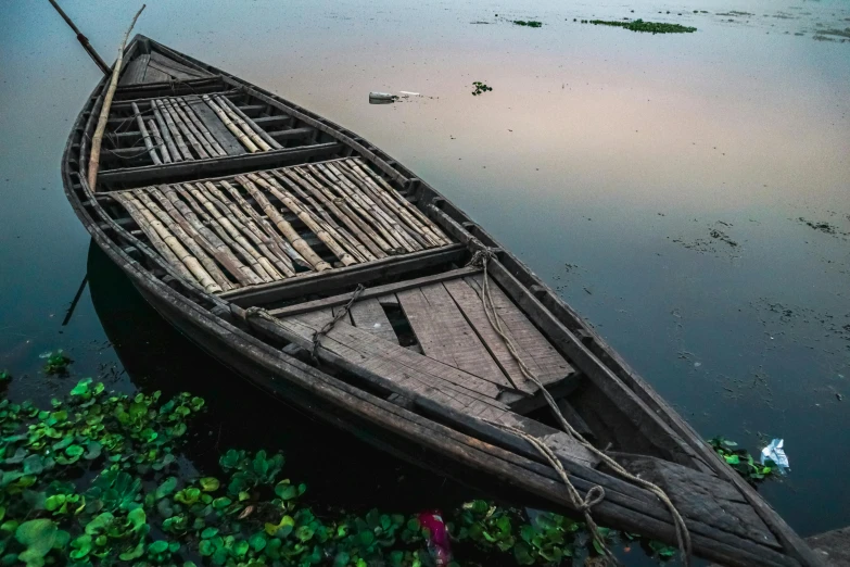 a small wooden boat floating in the middle of water