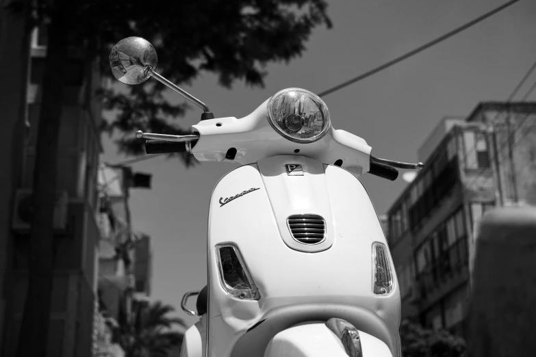 a motor scooter parked in front of a tall building