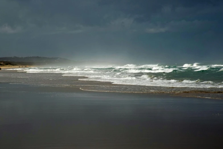 a lone surfer is coming into the water near the beach