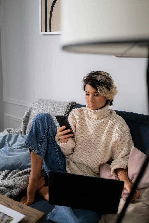 a woman sitting on a couch using her phone