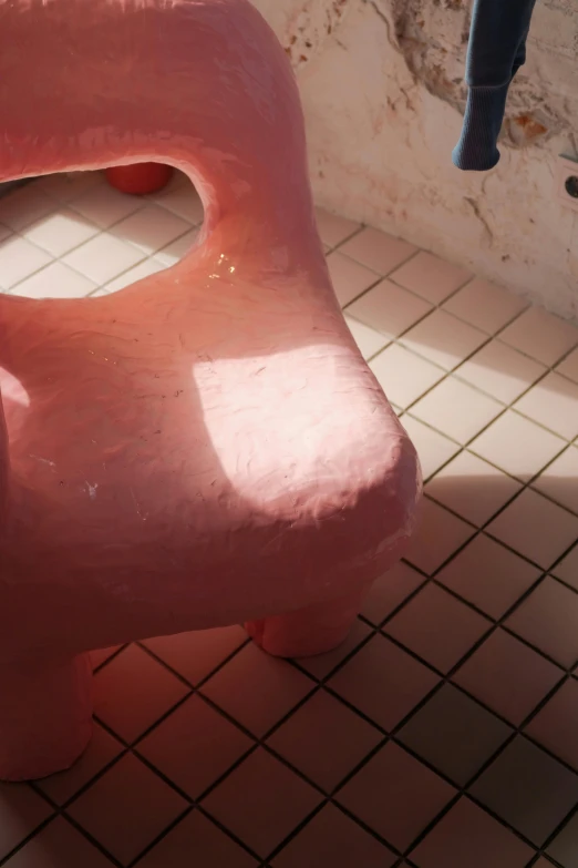 a pink bench sits on the floor with no one around