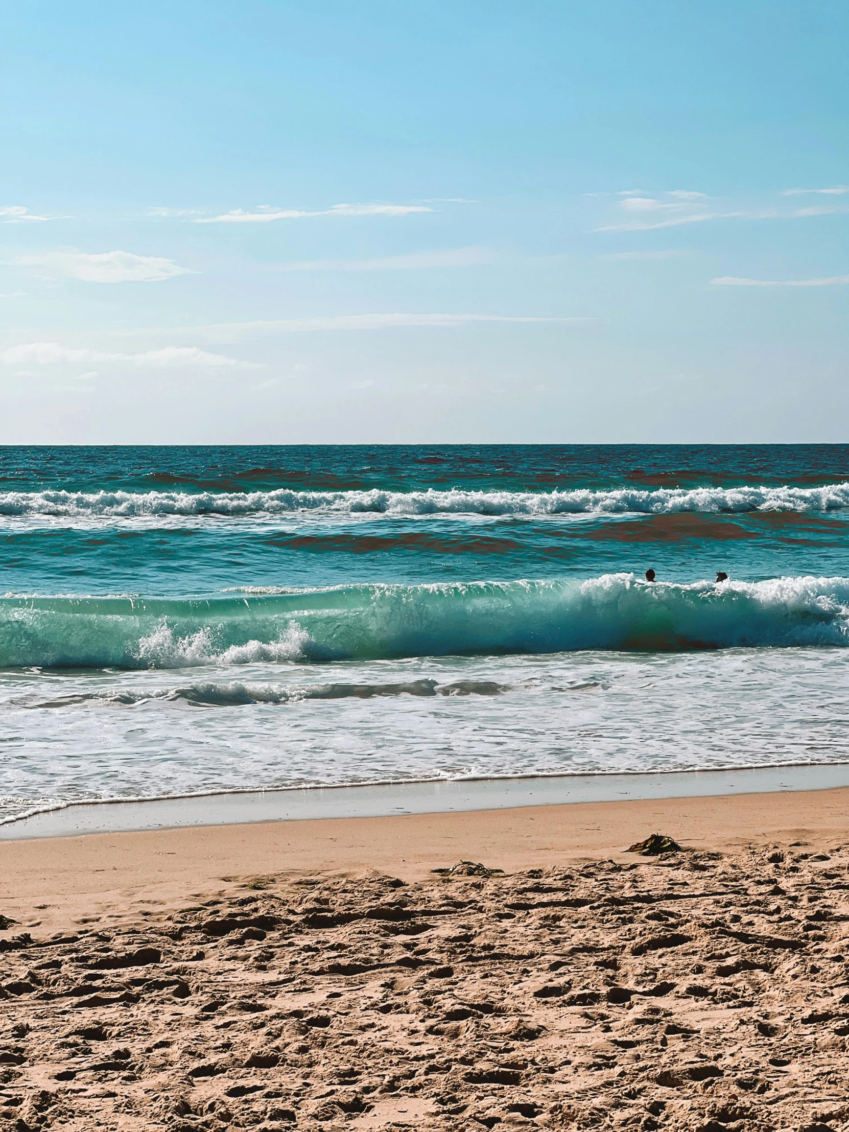 a surfboard is standing upright in the sand