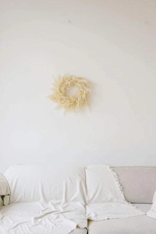 a couch with a small pillow and a white wreath on the wall