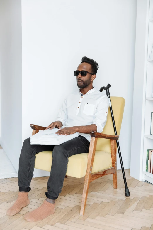 a man sitting in a chair holding a piece of paper