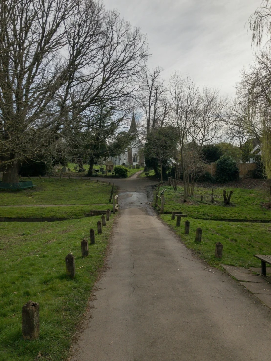 an empty driveway leading to a small field