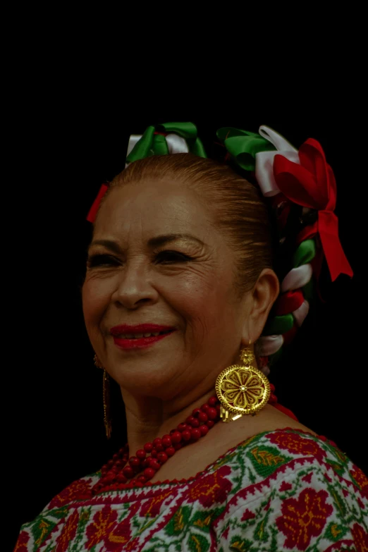 a woman wearing yellow earrings with a red bow in her hair