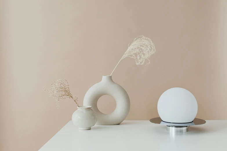 two white vases sitting next to each other on a table