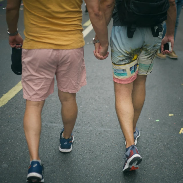 people walking down the street, with one holding the other's hand