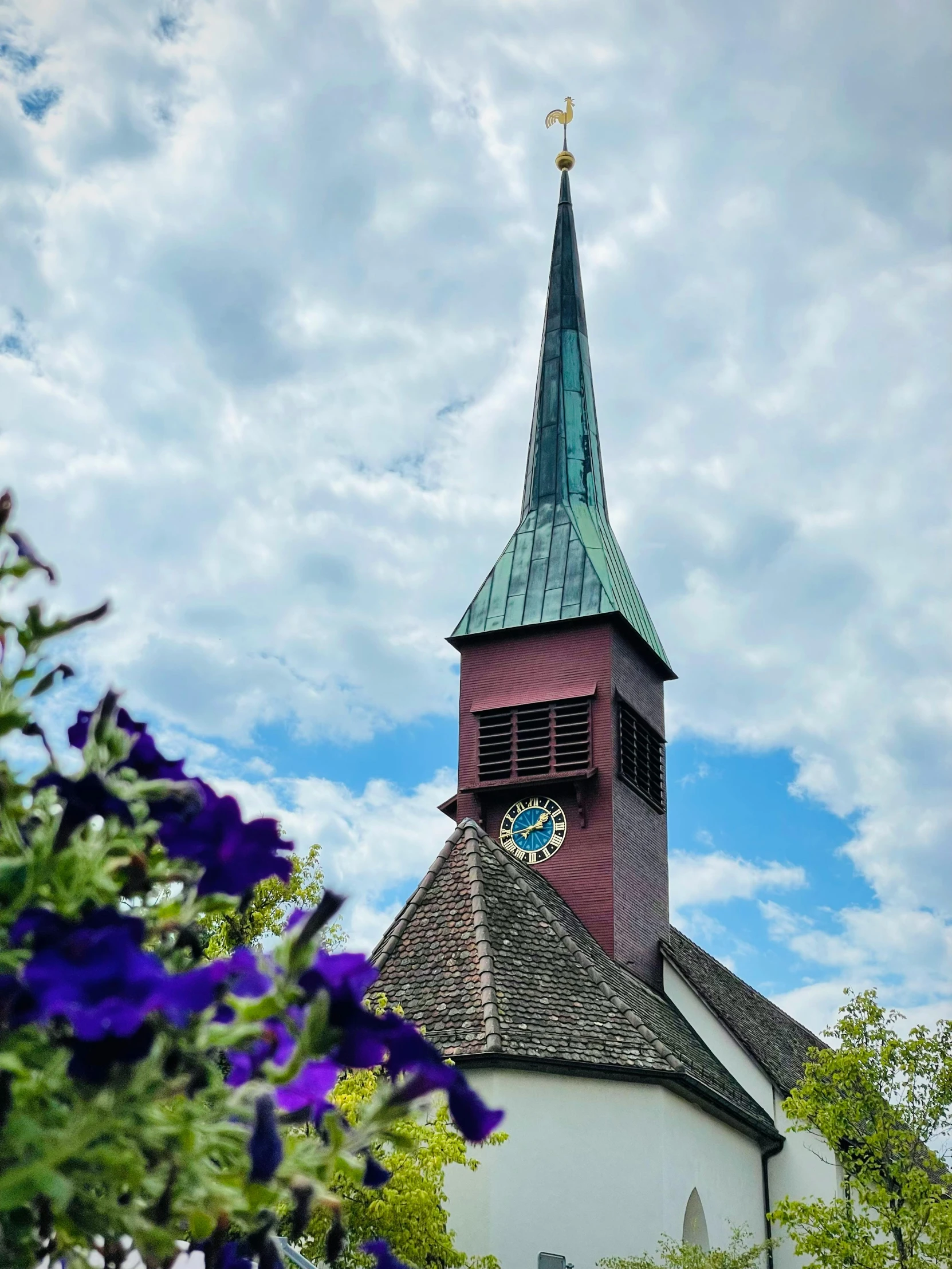 church steeple with a cross and flower in the foreground