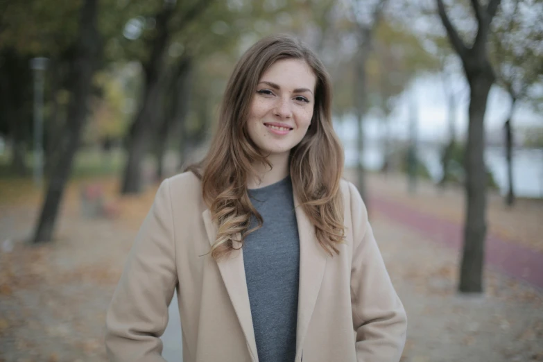 a young lady standing next to trees