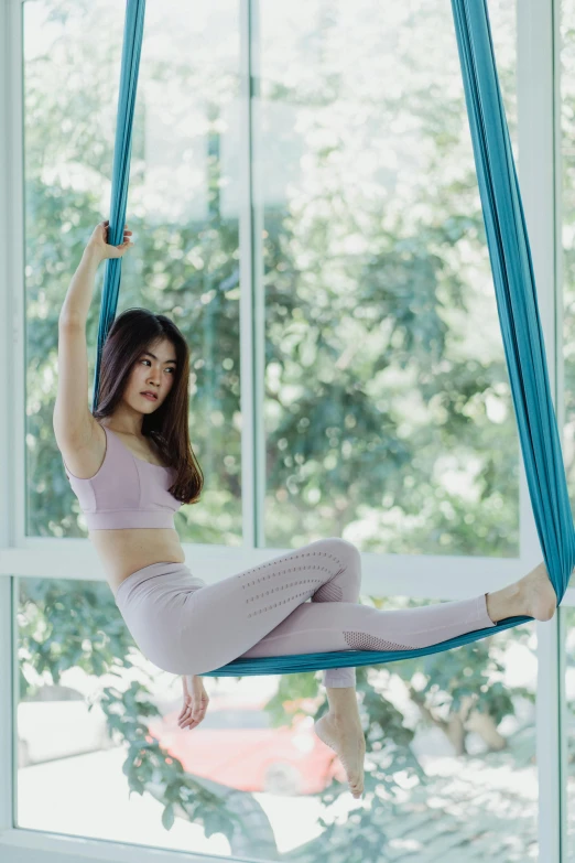  in aerial yoga position on hammock