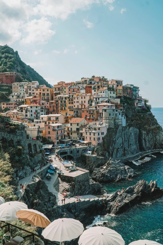 umbrellas are placed next to an ocean cliff and town