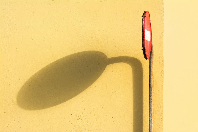 the shadow of a street sign and an umbrella on the wall