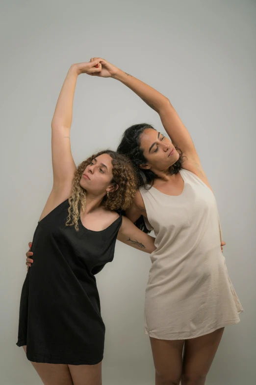 two girls are posing in front of a white background