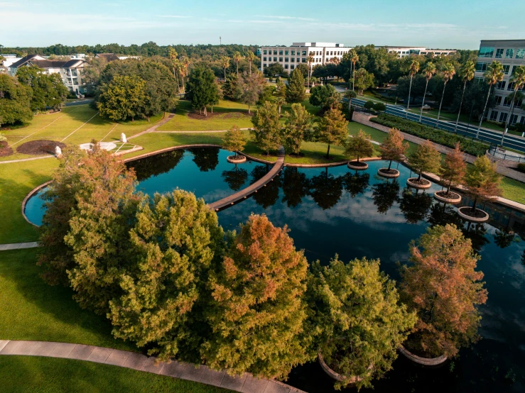 an aerial view of a park with trees, benches and small buildings