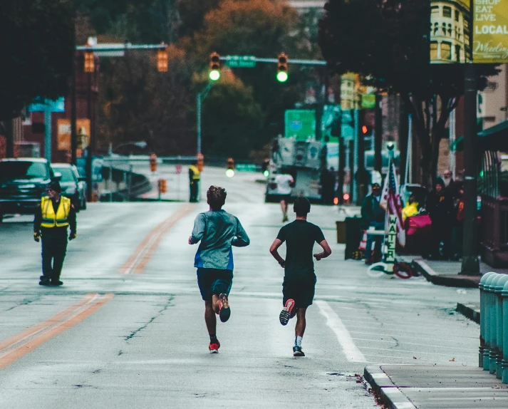 two people are running down the street together