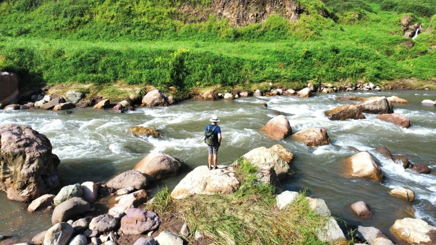 a person standing by a river looking down