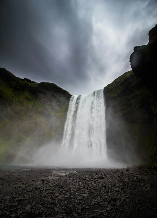 a person riding horses past a waterfall