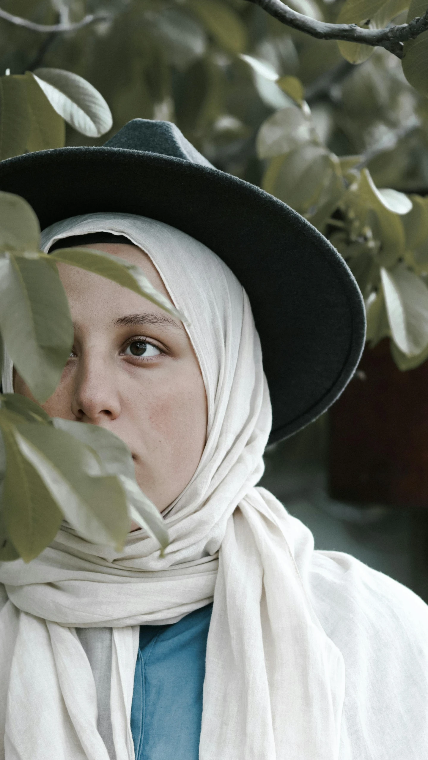 a girl in a white shawl and a black hat