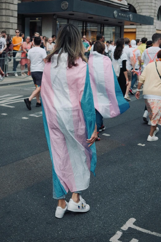 a woman in a striped robe crosses a street