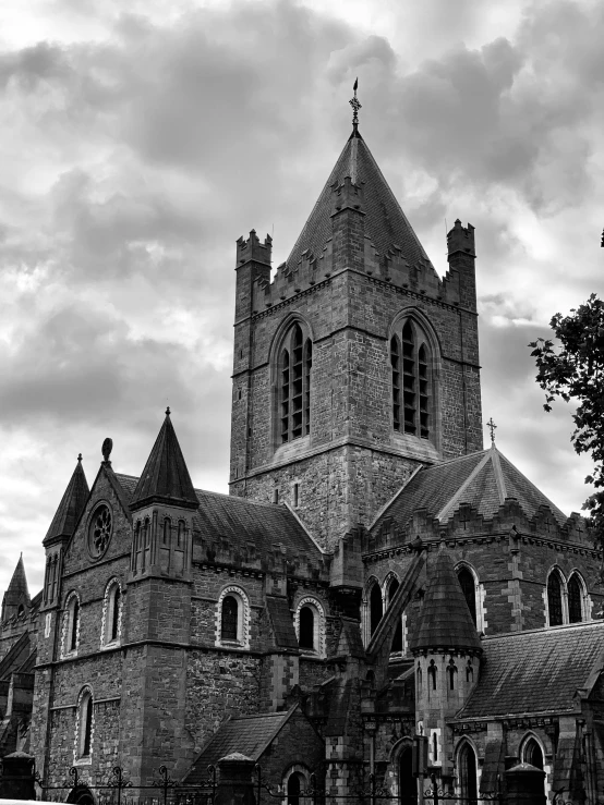 a church on a cloudy day, with two steeples and three clocks