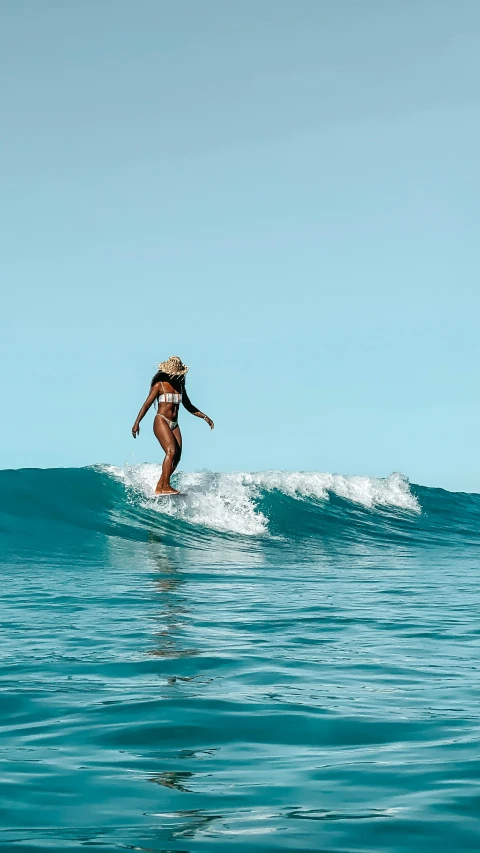 a person in a bikini rides a surfboard