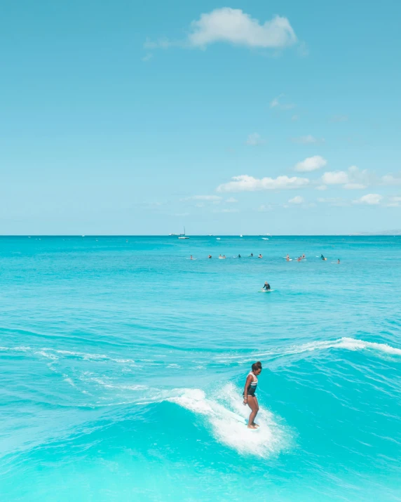 a young lady is riding the waves on a surfboard