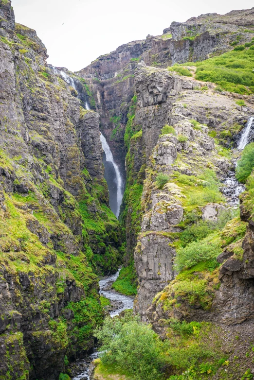 there are very tall rocks and small waterfalls