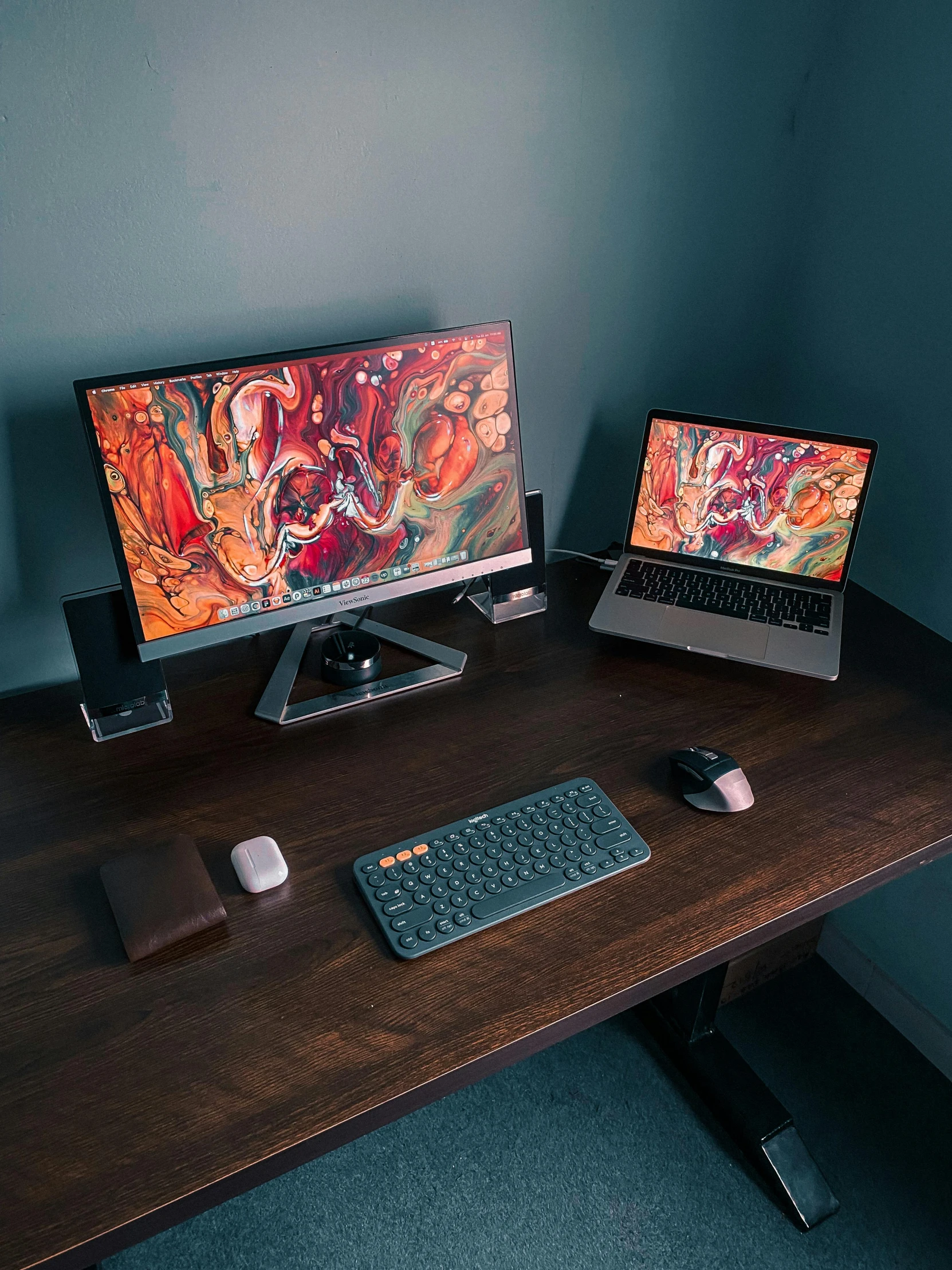 a couple of laptop computers sitting on top of a wooden table