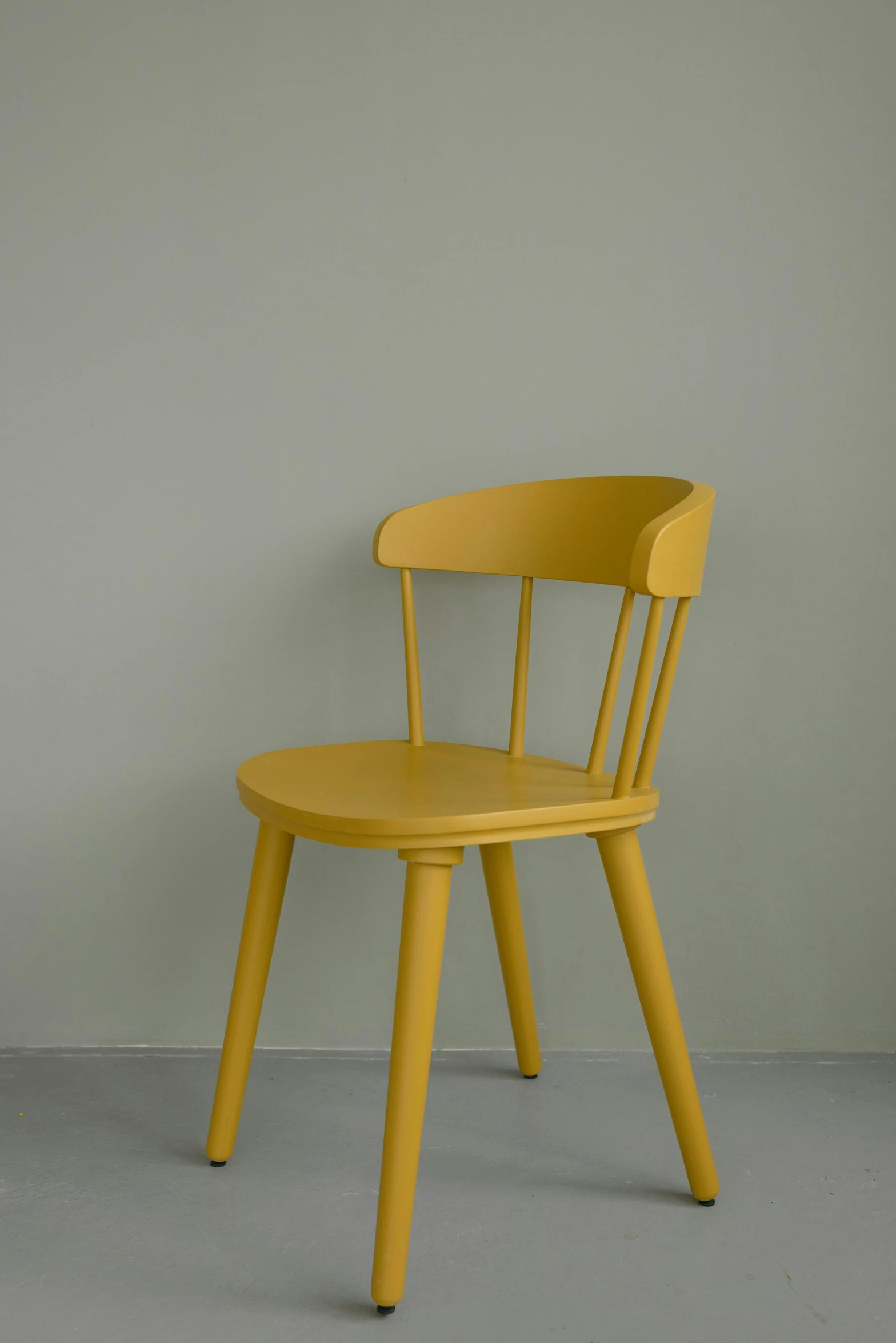 a chair leaning up against the wall, with only one leg in the shape of an egg chair