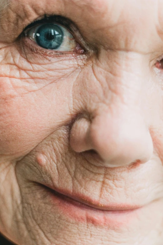 an older lady's face and blue eyes has wrinkles