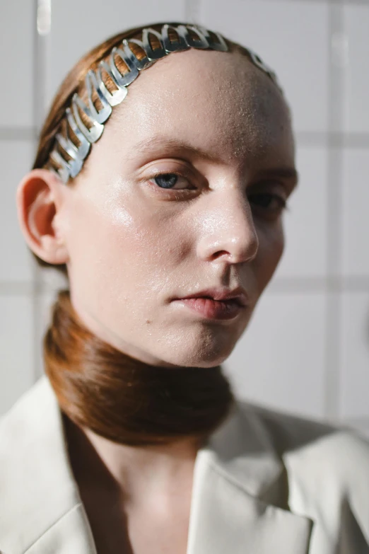 a model with a white jacket and a chain on her head