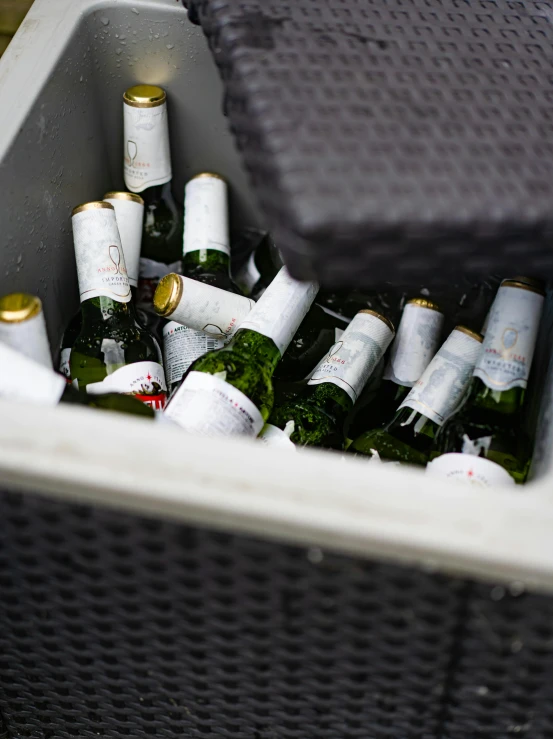 several bottles in a plastic bin with a few of them opened up