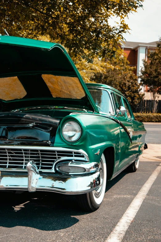 a green car parked in the middle of a parking lot