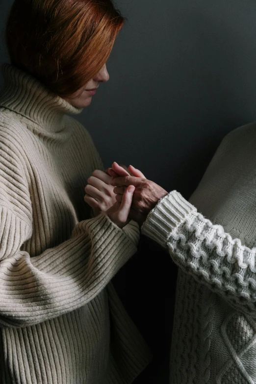 a woman holding the end of her finger near a pillow