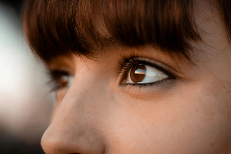 a woman with blue eyes stares into the distance