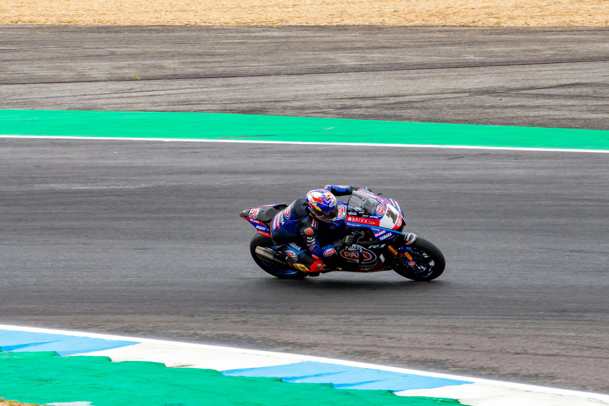 a motorcycle rider driving on the track behind another person