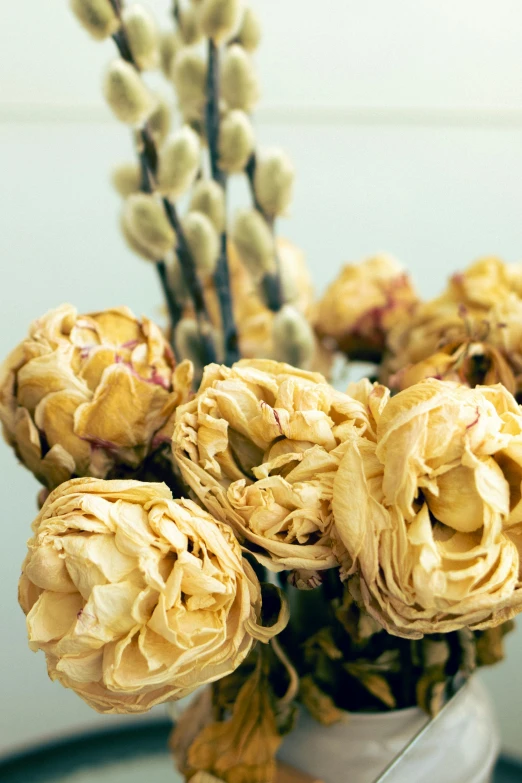 a vase with dried yellow flowers in it