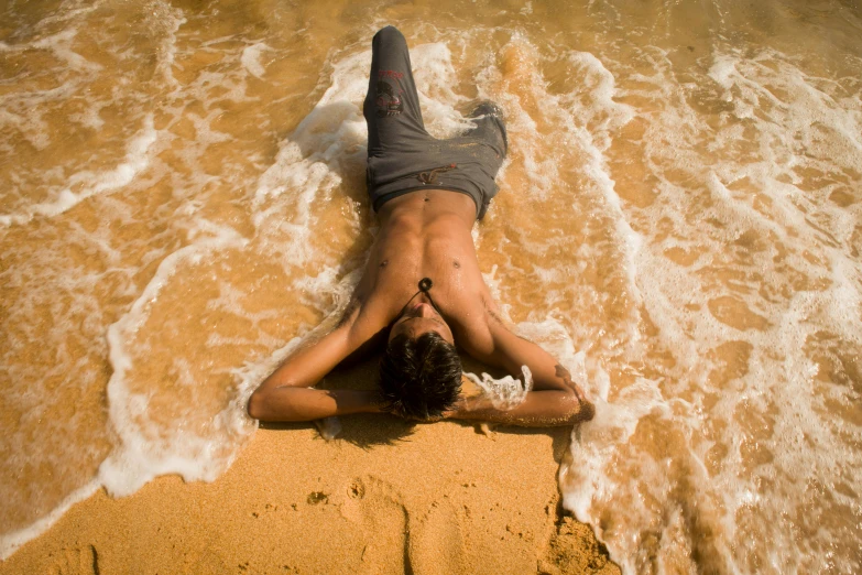 a person laying in the water at the beach