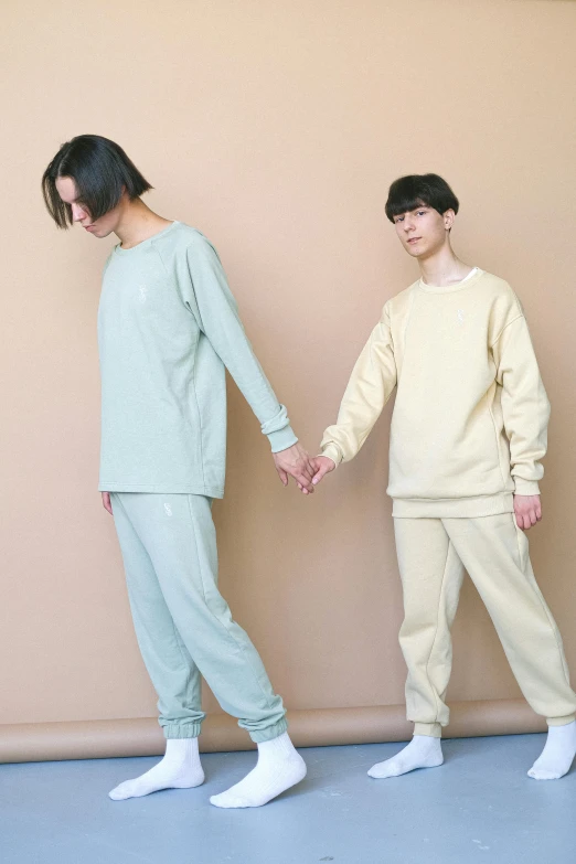 two people wearing pajamas standing in front of a wall