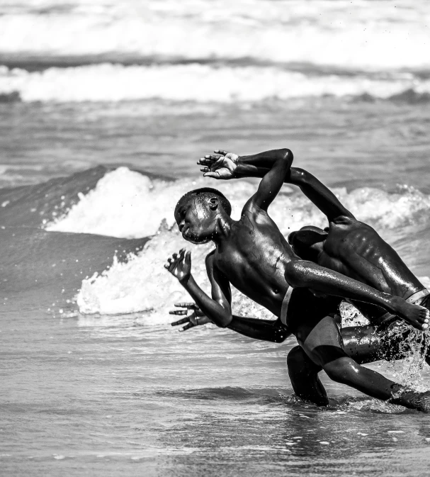 black and white po of a man falling off of a surfboard in the water